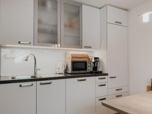 a kitchen with white cabinets and a microwave at Apartment Lina in Achenkirch