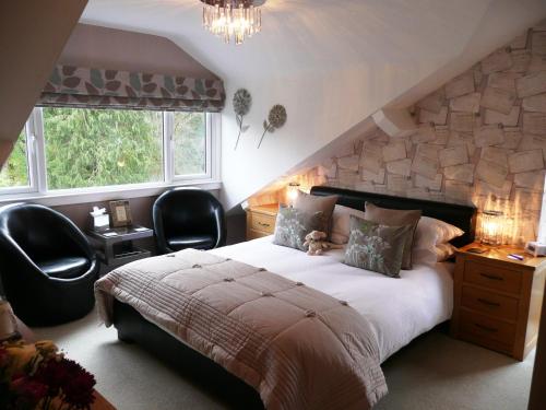 a bedroom with a large bed and two chairs at Glenville House - Adults Only - Incl FREE off-site health club with swimming pool, hot tub, sauna & steam room in Windermere