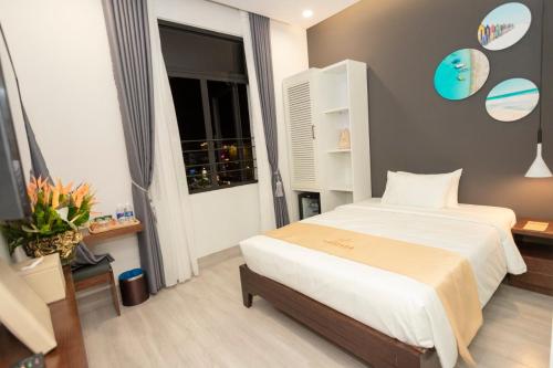a hotel room with a bed and a window at La Casa Tuy Hòa in Tuy Hoa