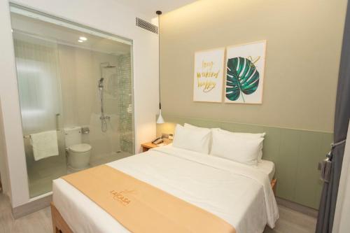 a bedroom with a large white bed and a shower at La Casa Tuy Hòa in Tuy Hoa