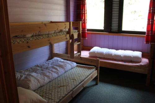 a room with two bunk beds and two windows at Bergfosshytta 1 sør in Ron