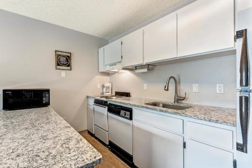 a kitchen with white cabinets and a sink at Bend Riverside Condos Near Downtown Bend in Bend