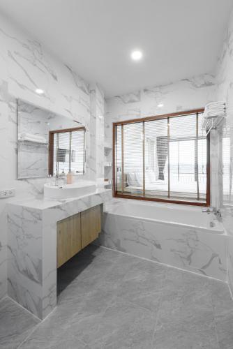 a white bathroom with a tub and a sink at Chiangkhan River Walk Hotel in Chiang Khan