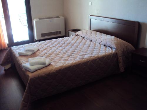 a bedroom with a bed with two towels on it at Hotel Terelidis House in Varikón