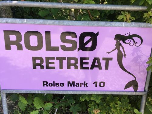 a sign for arosa retreat with a mermaid on it at Rolsø Retreat in Knebel