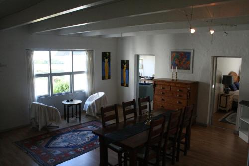 a dining room with a table and chairs and a kitchen at Rolsø Retreat - the apartment in Knebel