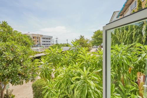 a view from the window of a house with plants at Talay Hotel and Villa Cha-am in Cha Am