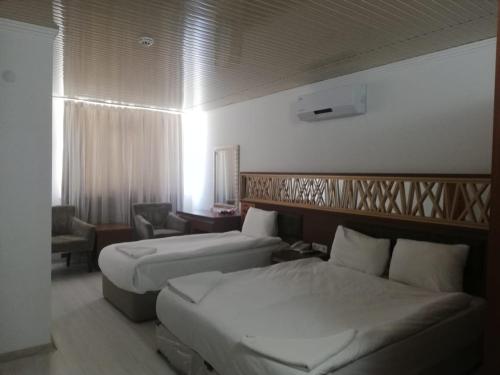 ein Hotelzimmer mit 2 Betten und einem Stuhl in der Unterkunft Gül Otel in Belek