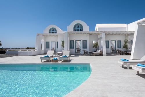 a villa with a swimming pool in front of a house at Santa Irina Luxury Sunny Lofts in Perivolos