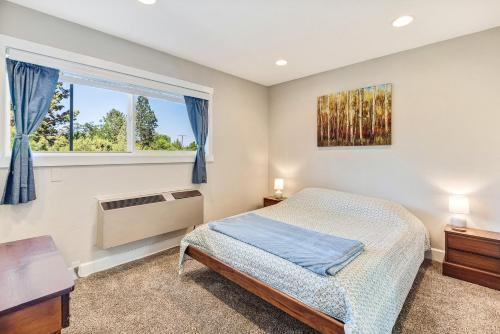 a bedroom with a bed and a window at Bend Riverside Condos Near Downtown Bend in Bend