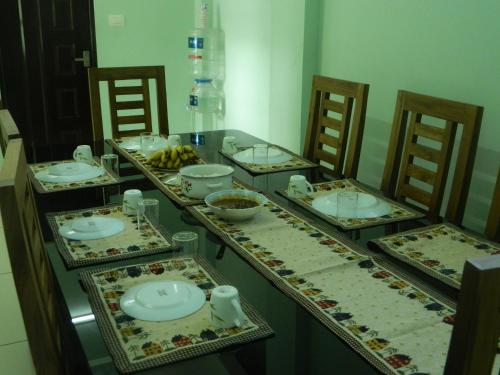 a table with plates and bowls of food on it at ZaMaRaYa Bed & Breakfast in Angamaly