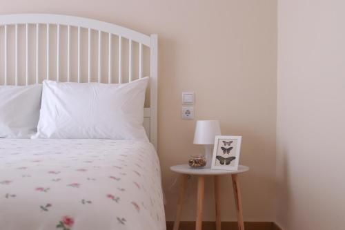 a bedroom with a white bed and a table with a lamp at ☆Minimal 6 floor Apartment in the Center of Patras in Patra