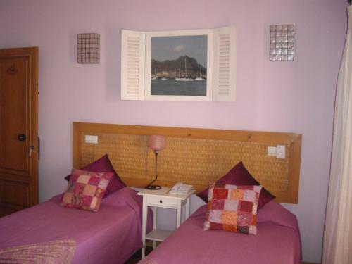a bedroom with two beds and a window and a phone at Kira's Boutique Hotel in Mindelo