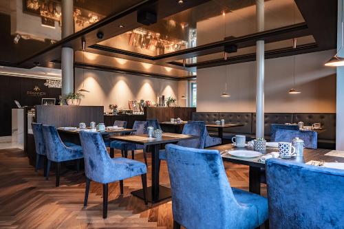 a dining room with blue chairs and tables at Prunner Luxury Suites - Adults Only in Schenna