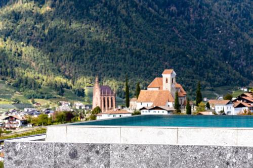 a resort with a swimming pool in front of a mountain at Prunner Luxury Suites - Adults Only in Schenna