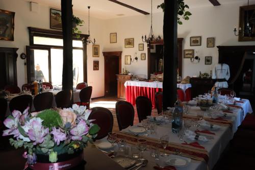 a room with tables and chairs with flowers on them at Pensiunea Grosspold in Miercurea Sibiului