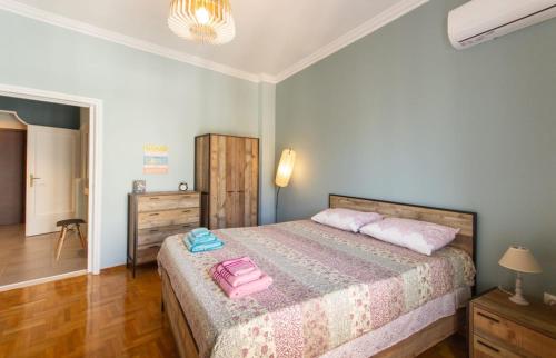 um quarto com uma cama com uma mala cor-de-rosa em ATHENS Penthous at Center em Atenas