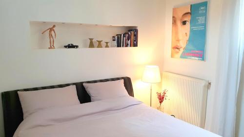 ミデルブルフにあるAccommodatie JURPLACE Centrumの白いベッドと壁にポスターが備わるベッドルーム1室が備わります。