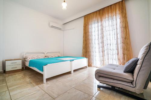 a small bedroom with a bed and a chair at Dimitra Beach Apartments - Nea Karvali Kavala in Néa Karváli