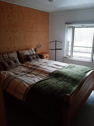 a bedroom with a large bed and a window at Beutenaken Drie in Beutenaken