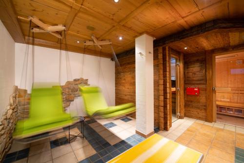 a room with green chairs in a wooden room at Großarler Jagdhaus in Grossarl