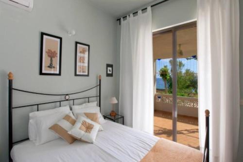 ein Schlafzimmer mit einem großen weißen Bett mit weißen Kissen in der Unterkunft Villa Tsampika in Pefki Rhodes