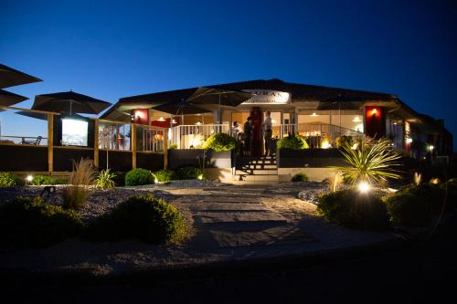 a house with lights in front of it at night at Logis Hôtellerie Les Brisants , Restaurant J M Perochon in Brétignolles-sur-Mer