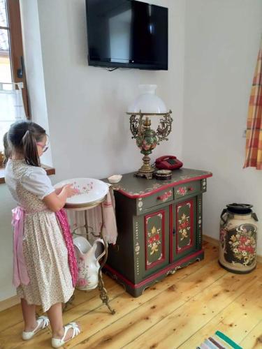a little girl standing next to a table with a plate at Retro Regina in Bazna