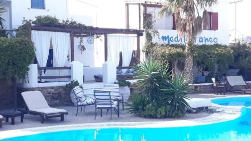 patio z krzesłami i basenem w obiekcie Hotel Mediterraneo w mieście Ios (Chora)