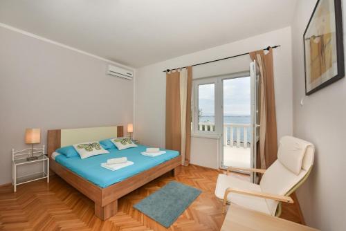 a small bedroom with a bed and a balcony at Apartments Markulin 3562 in Preko