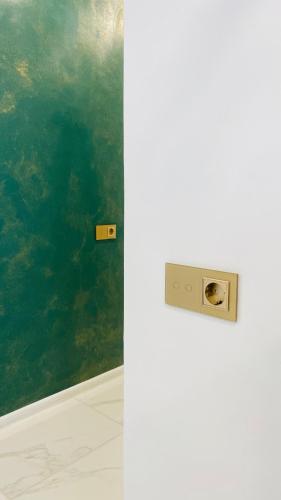 a white refrigerator in a room with a green wall at Green & White Apartament in Anykščiai