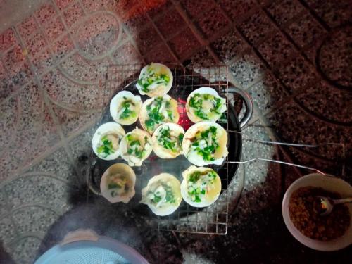 Tuấn Anh Motel في لاغي: مجموعة من الطعام فوق الشواية