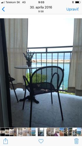 a table and chair on a balcony with a view of the ocean at Apartment Milena in Drasnice