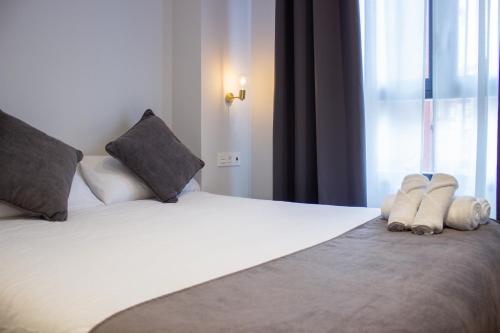 a bedroom with a large white bed with two pillows at Pensión B4R Self check in in Bilbao