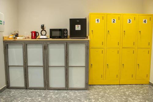 a row of yellow lockers in a room at Pensión B4R Self check in in Bilbao