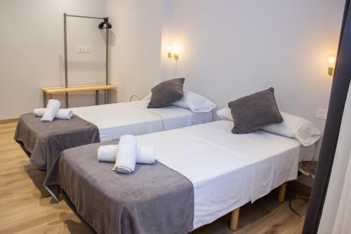 two beds in a room with a mirror at Pensión B4R Self check in in Bilbao