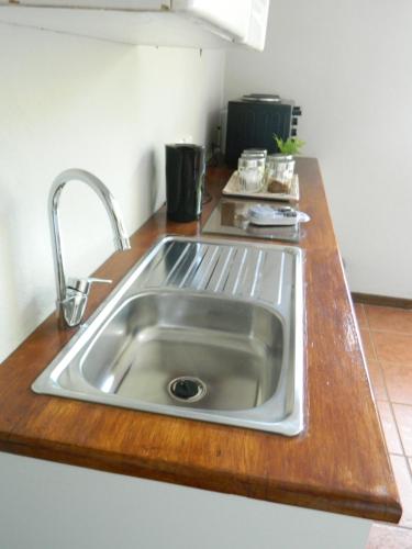 a kitchen counter with a stainless steel sink at Aloe Cottage in Nelspruit