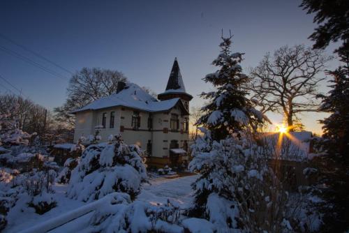 a house with a christmas tree in the snow at Turmvilla Vogtland in Oelsnitz