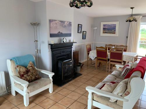 a living room with a couch and a fireplace at Cozy Coastal Cottage in Ballinskelligs, Kerry in Cahersiveen