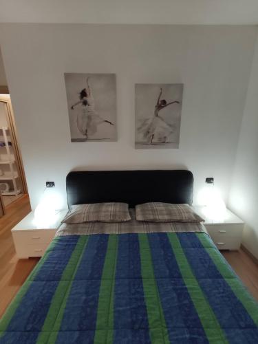 een slaapkamer met een bed met twee foto's aan de muur bij Bilocale in corte a Boltiere (BG) in Boltiere