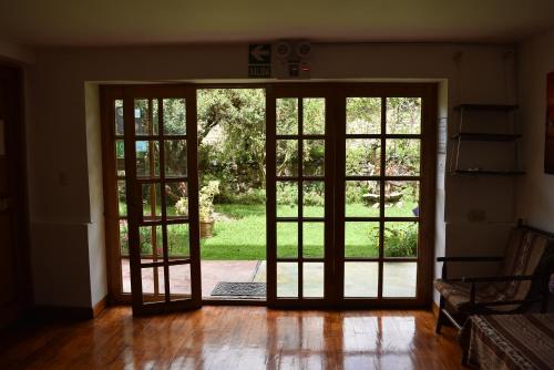 an open door with french doors to a yard at Apu Lodge in Ollantaytambo