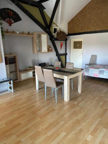 ein Wohnzimmer mit einem Tisch, Stühlen und einem Bett in der Unterkunft Hof Beuck in Travenhorst