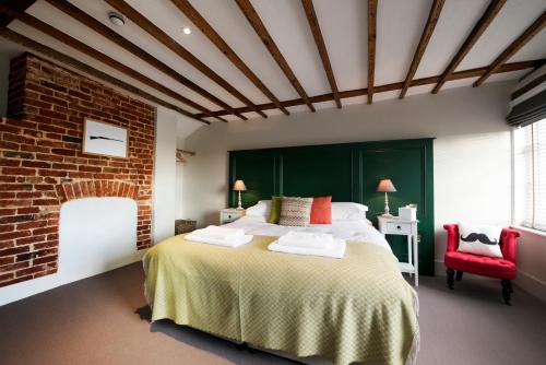a bedroom with a large bed and a brick wall at The Coach House in Potton