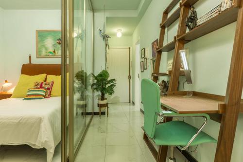 1 dormitorio con 1 cama y escritorio con silla verde en Flamingo Rosa en Arinaga