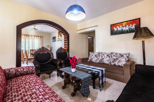 a living room with two couches and a table at Thor Villa, 5BHK-Private Pool-Cook-Caretaker in Assagao
