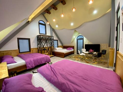 two beds in a room with purple sheets at Hotel Vương Bảo Đà Lạt in Da Lat