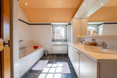 La salle de bains est pourvue de 2 lavabos, d'une baignoire et d'une fenêtre. dans l'établissement De Gouden Kop 3 Centrum Damme, à Damme