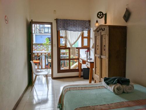 um quarto com uma cama, uma secretária e uma janela em La Abuelita Hostal em San Cristóbal de Las Casas