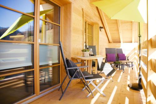 a room with chairs and a table with an umbrella at Leos Alpenchalet - inclusive Sommer Bergbahnticket und E-Auto Ladestation in Oberstdorf