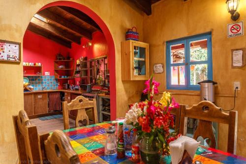 uma sala de jantar com uma mesa com flores em Posada del Abuelito (Hostel) em San Cristóbal de Las Casas